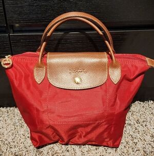Longchamp Le Pliage small handbag in red canvas with leather trim.